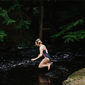 Woman jumping into river at Camp Glen Dye Woman jumping into river at Camp Glen Dye